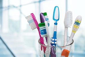 Multiple toothbrushes sitting in a cup