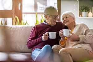 Happy senior couple cuddling on sofa