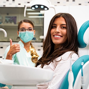 Smiling patient with happy dentist in the background