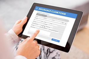 Person filling out insurance claim form on tablet